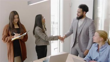 Çeşitli yetenekli profesyoneller, yaratıcılığa ilham veren ve tartışmalara katılan herkesi motive eden modern bir ofiste takım çalışmasını somutlaştıran bir toplantıda işbirliği yapıyorlar. 