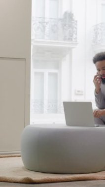 Afrika kökenli Amerikalı işadamı, atmosferi geliştiren şık mobilyalar ve canlı bitkilerle çevrili modern bir ofis veya modaya uygun bir çalışma alanında çalışmalarına odaklanmış durumda.