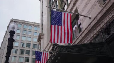 Sayısız Amerikan bayraklarının canlı ve renkli bir şekilde sergilenmesi, canlı kentsel bir ortamda kökleşmiş vatanseverlik duygusunu gözler önüne seren tarihi bir binayı belirgin bir şekilde süslemektedir.