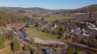 Arial çekim, Woodstock, Vermont 'un cazibesini yakalar, canlı sonbahar yaprakları, nehirler ve sakin tepeleri sergiler, izleyicilerin doğal güzelliğini ve cazibesini takdir etmelerini sağlar.