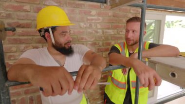 Yoğun bir inşaat alanında, farklı geçmişlerden iki inşaatçı başarılı ev yenileme ve tadilatlarında takım çalışması ve işbirliğinin önemini vurgulayan bir sohbete girişiyor.