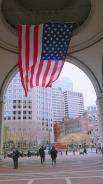 Boston 11.01.2024 Amerikan bayrağı modern binalar tarafından çerçevelenmiş yoğun bir şehir kemerinde dalgalanıyor. Yoldan geçenler onun canlı renklerine, topluluk ruhunun ve milli gururunun bir sembolüne hayran. 