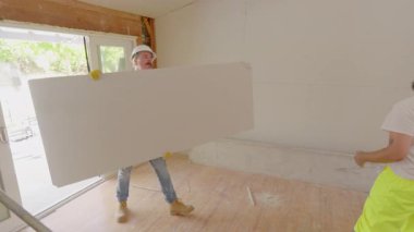 Çeşitli müteahhit ekipleri yoğun bir inşaat sahasında zorlu bir ev yenileme çalışmasını ortaklaşa yürütüyor, proje boyunca takım çalışmalarını ve planlama becerilerini sergiliyorlar.