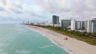 Sinematik hava çekimi Miami Sahili 'ni güzel bir şekilde yakalıyor, göz kamaştırıcı ufuk çizgisini ve resim gibi kıyı şeridini vurguluyor, bu da onu Amerika' da ideal bir lüks seyahat yeri yapıyor.