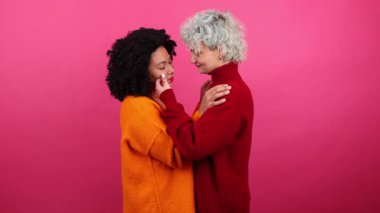 Genç, neşeli kadınların öpüşüp duygularını gösteren portresi. Mutlu sevgililerin bir randevuda kucaklaşmalarını yakından çek. Yüksek kalite 4k görüntü