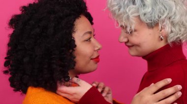 Sevgililer Günü 'nü kutlayan güzel LGBT çifti portresi. Kafkas ve Afrikalı Amerikalı kadınların sarılıp öpüşmelerini yakından çek. Yüksek kalite 4k görüntü