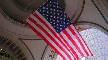 Tavandan sarkan büyük ve canlı bir Amerikan bayrağı ulusal değerlerimizin özünü somutlaştıran çarpıcı bir mimari ortamda vatanseverliğin ruhunu sembolize ediyor.