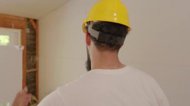 İki farklı müteahhit, yeni ev yenileme projesi için işlek bir inşaat sahasında etkin bir şekilde iş birliği ve planlama yapmaktadır.