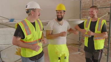 Canlı bir inşaat alanında, çeşitli inşaatçılardan oluşan bir grup, bir ev yenileme projesini tartışarak ve planlarken, bu alanı dikkate değer bir şeye dönüştürmeyi vaat ediyor.