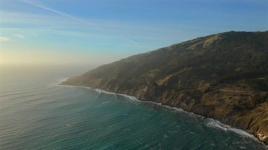 Güneşin engin Pasifik Okyanusu 'nun üzerinde güzel bir şekilde battığı Kaliforniya' nın ünlü ve pitoresk 1 numaralı karayolu boyunca Büyük Güneş 'in nefes kesen kıyı şeridini gözlemleyin.