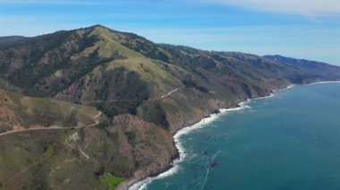 Kaliforniya, Big Sur 'da, engebeli kıyı şeridi boyunca bir arabanın hareketli dağlarla çevrili olduğu otoban 1' in çarpıcı hava manzarasını tecrübe edin. Bu yol doğa aşıkları için gereklidir.