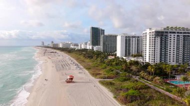 Havadan çekilen bir görüntü Miami sahillerinin ufuk çizgisini ve çarpıcı sahil şeridini yakalıyor. Lüks sahil bölgelerini vurguluyor. Bu nefis yere ziyaretiniz sırasında dinlenmek ve rahatlamak için ideal.