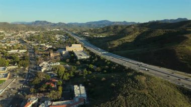 Çarpıcı hava görüntüleri, Los Angeles 'ın pitoresk banliyölerinde yuva yapmış dolambaçlı bir otoyolu, canlı şehir manzarasını, hem doğa hem de şehir hayatının inanılmaz güzelliğini gözler önüne seriyor.