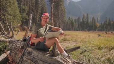 İnsanoğlu güzel Yosemite Milli Parkı 'nda gezer, nefes kesen dağlar ve doğal güzelliği ve macera ruhunu vurgulayan gür ormanlar arasındaki haritayı inceler.