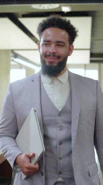 Çağdaş bir çalışma ortamında, iyi giyimli bir Afrikalı Amerikalı işadamı, iş dünyasına dinamik ve yenilikçi bir yaklaşımı somutlaştıran pozitiflik, bencillik ve profesyonellik yayar.