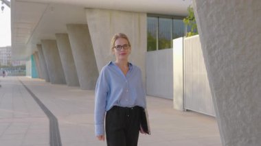 İlham verici bir şehir ortamında, kararlı bir iş kadını laptopuyla güvenle yürür, hırsını ve bağlılığını gösterir, modern yenilikleri ve profesyonel başarıları somutlaştırır.