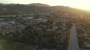 Los Angeles 'ın banliyö bölgesini gösteren inanılmaz hava görüntüleri canlı yeşil tepeleri, yoğun otoban trafiğini ve ufukta nefes kesici bir günbatımının nefes kesici güzelliğini gösteriyor.