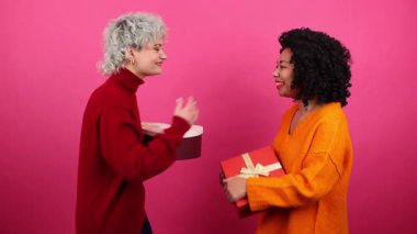 Güzel Afro-Amerikan ve Kafkas kadınlarının yakın çekim görüntüsü neşeli görünüyor. Romantik yıldönümünü kutlayan kadınlar. Yüksek kalite 4k görüntü