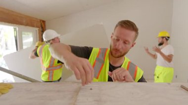 Çeşitli müteahhitlerden oluşan bir ekip, önemli bir ev yenileme projesi için çeşitli araçlar ve zanaatkârlık becerilerini kullanarak, hareketli bir inşaat sahasında özenle işbirliği yapıyor.