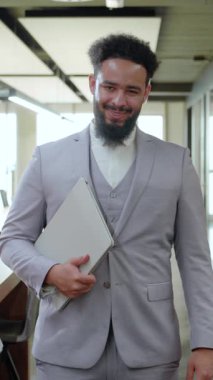 Çağdaş bir çalışma ortamında, iyi giyimli bir Afrikalı Amerikalı işadamı, iş dünyasına dinamik ve yenilikçi bir yaklaşımı somutlaştıran pozitiflik, bencillik ve profesyonellik yayar.