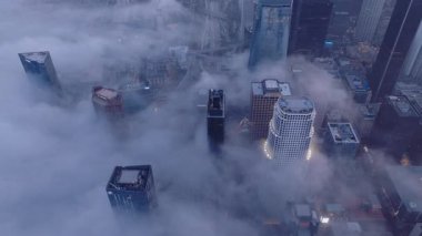 Los Angeles 11.25.2024. Los Angeles şehir merkezinin göz kamaştırıcı ve nefes kesici hava manzarası, sisli ve yumuşak bulutlarla kaplanmış, mistik ve sakin atmosferdeki ikonik şehir siluetini yakalıyor.