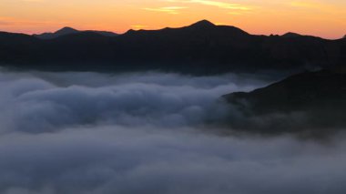 Büyüleyici Malibu dağları ve gür tepelerinin bulutları üzerinde nefes kesici bir hava manzarası, gün batımında dingin bir sis, unutulmaz bir şekilde büyüleyici güzellikler sergiliyor.