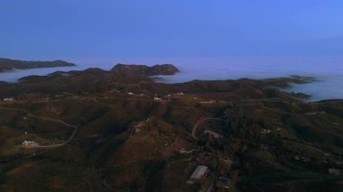 Nefes kesici drone görüntüleri Malibu dağlarının çarpıcı güzelliğini yakalar. Yemyeşil tepeler, tüylü bulutlar ve büyüleyici bir günbatımı manzarası sergiliyor.