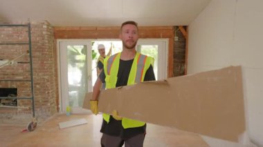 Aralarında Afro-Amerikan, İspanyol ve Kafkas işçilerin de bulunduğu çeşitli müteahhitlerden oluşan bir ekip, bir ev yenileme sahasında inşaat işleriyle meşguldü. Takım çalışması ve profesyonellik sergiliyorlar..