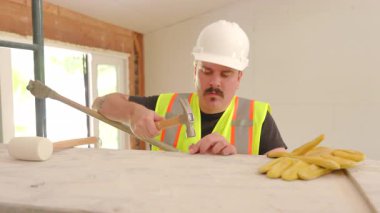 Erkek İnşaatçı, ev yenileme projesinde Hummer 'ını kullanarak, yoğun bir inşaat alanında, bir ev planlamak ve yenilemek için çeşitli araçlar kullanır, işçilik ve inşaat alanındaki çeşitliliğin önemi