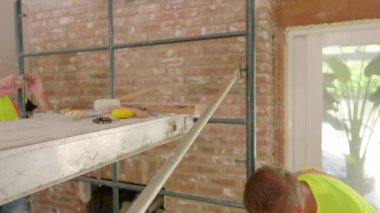 Hareketli bir inşaat alanında, çeşitli yetenekli inşaatçılar etkileyici bir takım çalışması ile onların aletlerini kullanarak heyecan verici yeni bir ev yenileme projesinde etkili bir işbirliği içinde çalışırlar.