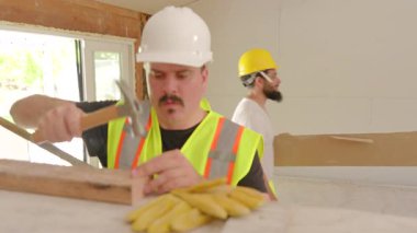 Becerikli bir inşaat ekibi, çeşitli aşamalar ve çeşitli malzemelerin yer aldığı kompleks bir ev yenileme çalışması için takım çalışması ve planlama sergileyen yoğun bir inşaat sahasında işbirliği yapıyor.