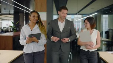 Profesyonel iş adamlarından oluşan çeşitli gruplar ofiste birlikte vakit geçiriyorlar. Elinde tablet bilgisayar olan kadın erkeklere gösterir. Morden ortak çalışma alanı. Yavaş çekim