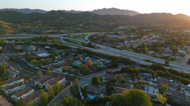 Los Angeles 'ın çarpıcı banliyölerini gösteren hava görüntüleri gür tepeler, görkemli dağlar, hareketli otoyollar ve hareketli trafik günbatımında büyüleyici bir manzara yaratıyor.