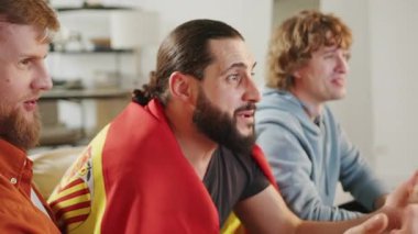 Erkek İspanyol taraftarlar televizyonda futbol maçı izleyip İspanya takımı için tezahürat yapıyorlar. Avrupa Almanya ve Dünya Futbol Kupası, Almanya 2024, 2026 ABD, Kanada, Meksika. Spor ve futbol hayranları. Yavaş Hareket