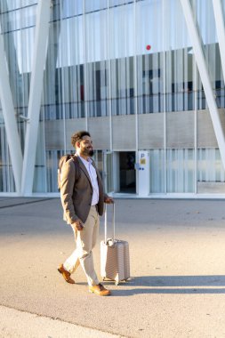 Kendine güvenen bir işadamı şık bir bavulla, seyahat, hırs ve sayısız mesleki tutkusunu sembolize eden şık ve modern bir binanın önünde kasıtlı olarak adım atar.