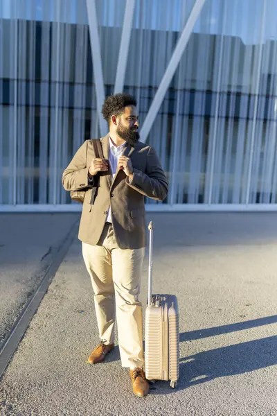 Moda bir bavul ile şık bir kıyafet içinde şık bir adam, canlı bir şehir ortamında duruyor, heyecanlı bir macera ve keşif dolu heyecanlı bir yolculuk bekliyor