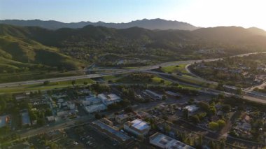 Havadan çekilen görüntüler Los Angeles 'ın banliyö manzarasını yakalar, verimli tepeler, yoğun otoyollar, ve nefes kesici bir gün batımına karşı hareketli bir otoyol kavşağı, manzarayı seyredilecek bir manzara yapar.