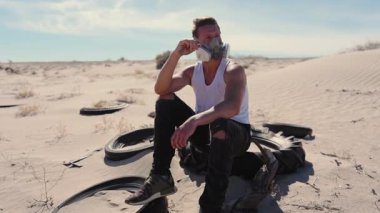 Solunum cihazındaki dayanıklı bir adam ıssız bir çölde oturuyor ve post-tapokaliptik bir senaryoyu akla getiriyor. Lastik kalıntılarıyla çevrili halde, sert güneş ışığı altında hayatta kalmayı ve yalnızlığı derin bir şekilde düşünür.