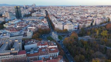 Madrid 'in günbatımındaki ikonik Puerta de Alcal ve El Retiro parkının canlı şehir manzarası ve Avrupa tarihi eşliğinde sersemletici hava aracı görüntüleri. İspanya