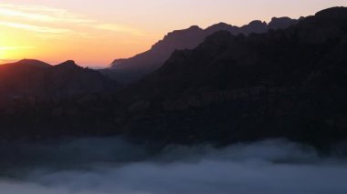 Malibu dağlarının nefes kesen hava manzarası, yemyeşil tepeler ve gün batımında dingin sis, büyüleyici doğa severler ve herkesi sakin güzelliğini keşfetmeye davet ediyor.