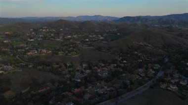 Unutulmaz bir maceraya atlayın ve Malibu dağlarının nefes kesici hava manzarasına tanık olun, bereketli tepeler büyüleyici günbatımı sisi ile buluşur, büyüleyici ve huzurlu bir manzara yaratır.