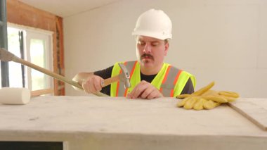 Erkek İnşaatçı, ev yenileme projesinde Hummer 'ını kullanarak, yoğun bir inşaat sahasında, etkili bir takım çalışması ve stratejik planlama ile iddialı bir ev yenileme projesiyle uğraşmaya hazır.