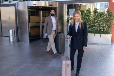 İki iş gezgini, bir erkek ve bir kadın, bir otelin girişine varırlar, bavullarını çekerler ve onları bekleyen hizmet ve konukseverlik beklentisi içinde, konaklamaya hazırdırlar.