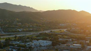 Hava manzarası, yeşil tepeleri, görkemli dağları ve işlek otoban trafiği ile güzel bir Los Angeles banliyösünü gözler önüne seriyor. Hepsi de güneşin sıcak altın parıltısıyla yıkanmış ve muhteşem bir manzara yaratıyor.