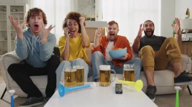 Çok ırklı sporseverler favori takım için tezahürat yapıyor, TV 'de maç izliyor ve abur cubur yiyor. Avrupa sporu. Dünya futbolu, ABD, Kanada, Meksika. Spor ve futbol hayranları. Olimpiyat Oyunları, Yavaş Hareket