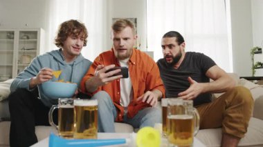 Futbol hayranları favori takım için tezahürat yapıyor, akıllı telefondan maç izliyor ve bira içiyor. Avrupa ve Dünya futbolu, ABD, Kanada, Meksika. Spor ve futbol hayranları. Oyunlar Yavaş Hareket