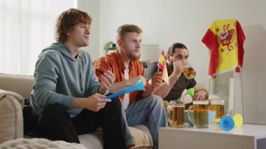 Erkek İspanyol futbol taraftarları favori takım için tezahürat yapıyor, TV 'de maç izliyor ve bira içiyor. Avrupa Almanya ve Dünya Futbol Kupası ABD, Kanada, Meksika. Spor ve futbol hayranları. Yavaş Mo