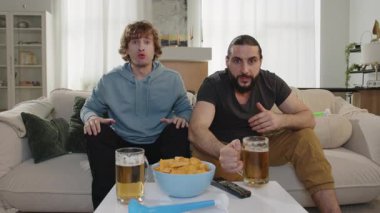 Erkekler televizyonda maç izleyip bira içerken kutlama golünü kutluyor. Avrupa Almanya ve Dünya Futbol Kupası ABD, Kanada, Meksika. Futbol, spor ve futbol fanatikleri. Olimpiyat Oyunları