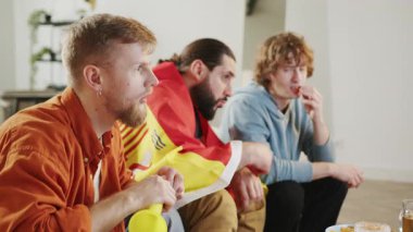 Erkek İspanyol taraftarlar TV 'de maç izleyip abur cubur yiyorlar, İspanya takımına tezahürat yapıyorlar. Avrupa spor futbolu. Futbol kupası. Spor ve futbol hayranları. Ağır çekim. Dünya Spor Oyunları