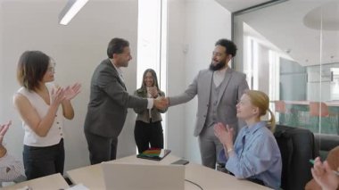 Yetenekli bir ekip, şık bir konferans salonunda önemli bir iş anlaşmasının imzalanmasındaki başarılarını kutluyor ve süreç boyunca takım çalışmasının ve işbirliğinin önemini vurguluyor.